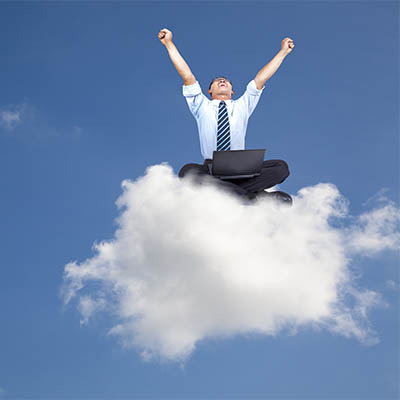 man sitting on a cloud celebrating with his fists in the air