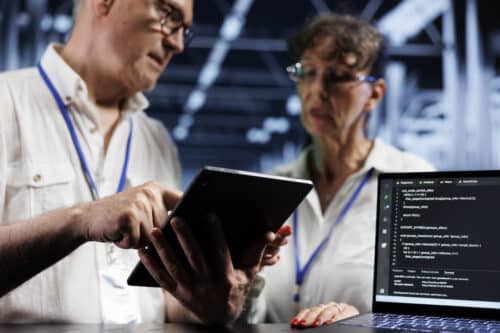 Two IT professionals work on updates after the Windows 10 EOL.